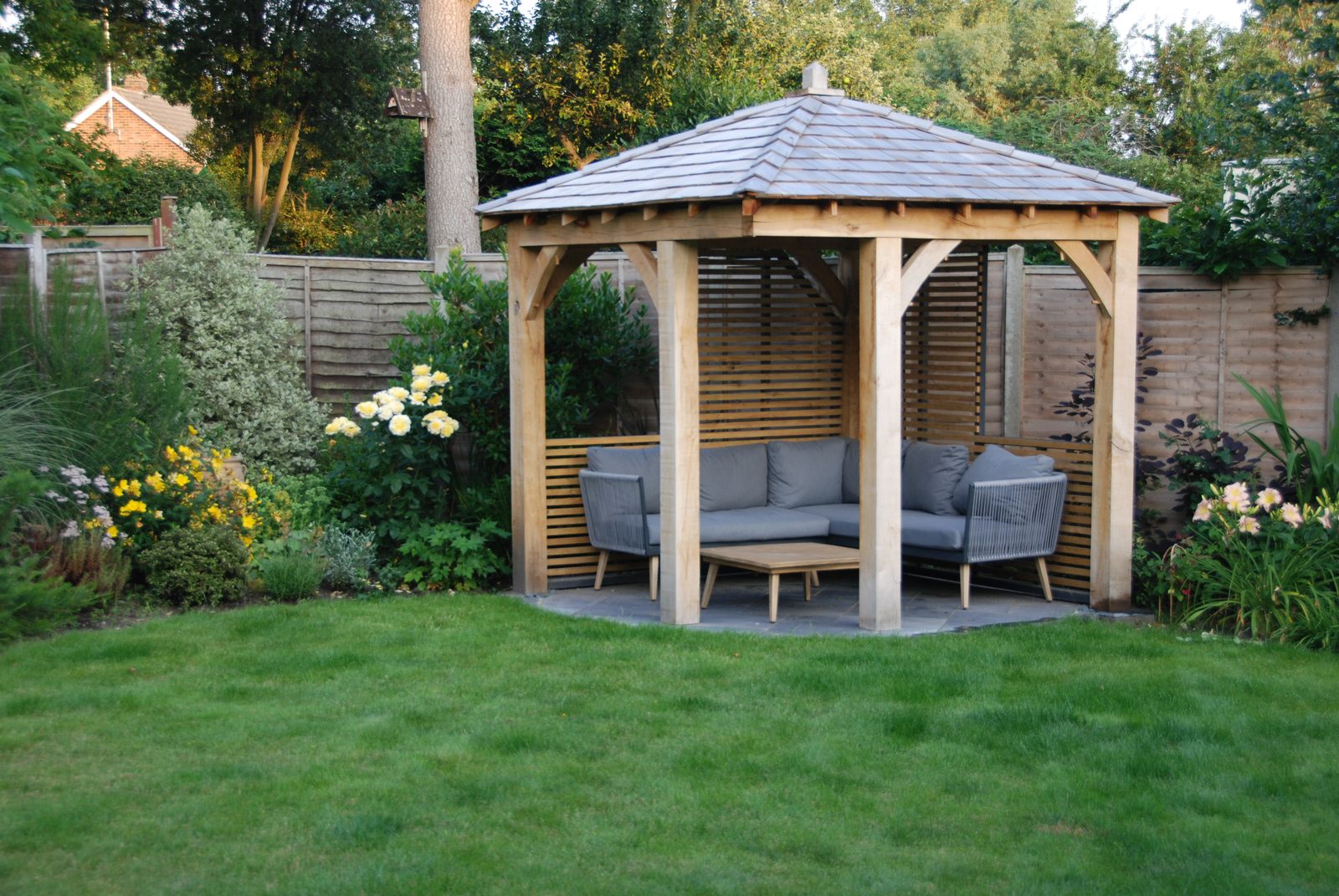 An oak shelter at the end of the lawn